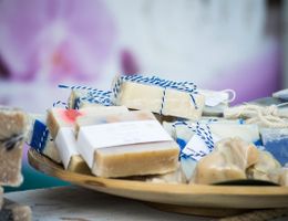 Ein Holztablett mit handgemachten Seifenstücken, die in Papier und Schnur verpackt sind.
