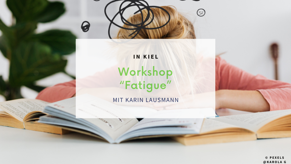 Person sitzt vor einem Bücherstapel, der Kopf ruht auf den Händen auf dem Tisch.