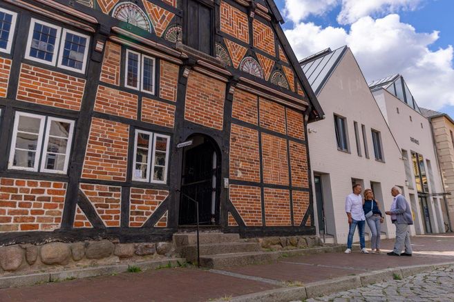 Eine Person geht eine Treppe hinunter mit Blick auf eine malerische Landschaft. Bunte Bäume und Häuser sind in der Ferne zu sehen.